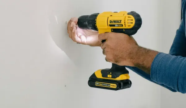 Worker installing sheetrock drywall before painting.